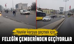 Yayalar karşıya geçmek için feleğin çemberinden geçiyor