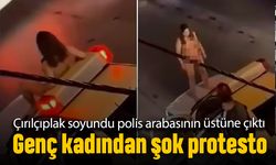 Bir kadın kıyafetlerini tamamen çıkarıp polis arabası üstüne çıktı