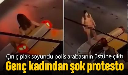 Bir kadın kıyafetlerini tamamen çıkarıp polis arabası üstüne çıktı